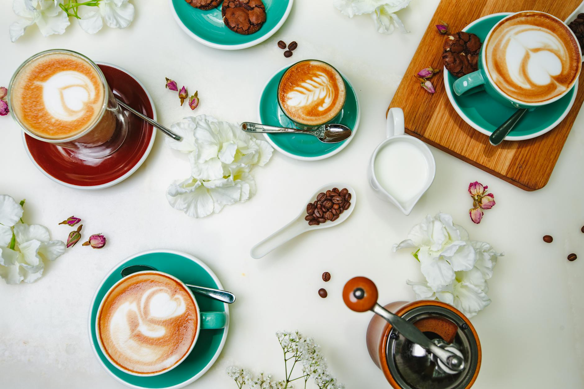 cups of hot coffee with froth art on a white surface